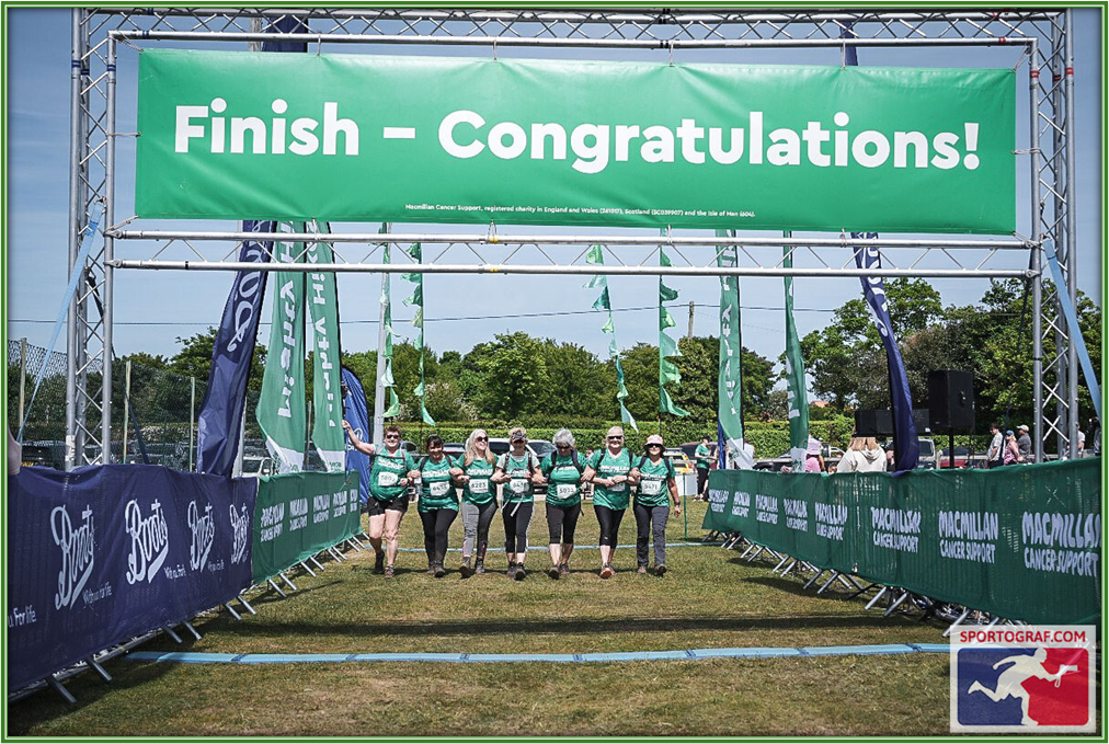 Members of staff crossing the finish line after the Mighty Hike charity event